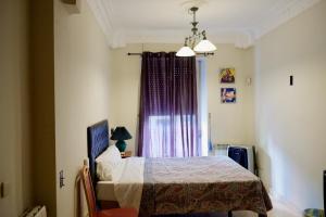 sypialnia z łóżkiem i oknem z fioletowymi zasłonami w obiekcie BOOKINGHAM ★Apartaments & Suites w Madrycie