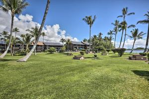 a park with benches and palm trees in front of a building at Kaunakakai Escape Heated Pool and Beach Access in Kaunakakai