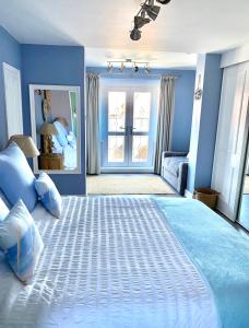 a bedroom with a large bed with blue walls at Sea Breeze Apartment Skegness in Skegness