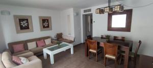 een woonkamer met een bank en een tafel bij TOYO Apartamento golf y playa in El Toyo
