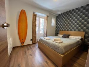 - une chambre avec un lit et une planche de surf sur le mur dans l'établissement CENTRO - PARKING Free - MUSEO ATUAIRE VUT-09-234, à Burgos