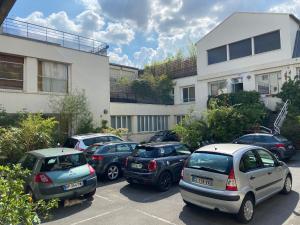 a group of cars parked in a parking lot in front of a building at Loft aux portes de Paris - Parking gratuit in Bagnolet