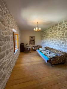 a living room with a couch and a stone wall at Queen’s vintage house in Podgorica