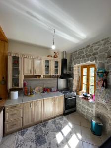 a kitchen with wooden cabinets and a stone wall at Queen’s vintage house in Podgorica