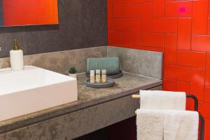a bathroom with a white sink and red walls at Secret Beach House in Água de Alto +69 photos