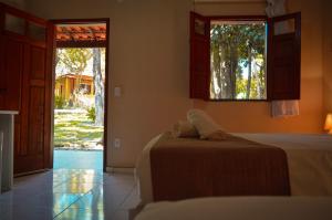 1 dormitorio con 2 camas y puerta a un patio en Villaflor Pousada, en Vale do Capao
