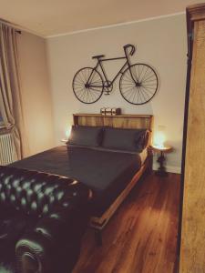 uma bicicleta pendurada na parede acima de uma cama em B&B San Paolo Sweethome em Parma