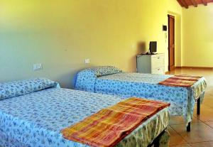 a bedroom with two beds and a television in it at Villa Magni in Pistoia