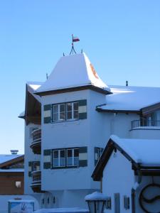 a white building with a cross on top of it at Alpen Glück Schlössl Unterm Rain in Kirchberg in Tirol