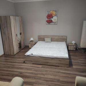 a bedroom with a bed and two tables with chairs at Dédi Apartman Sátoraljaújhely in Sátoraljaújhely
