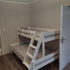 a white bunk bed with a ladder in a room at Dédi Apartman Sátoraljaújhely in Sátoraljaújhely