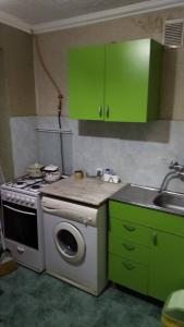 a kitchen with green cabinets and a stove and a sink at Kandelaki in Tbilisi City