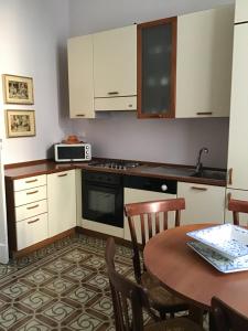 una pequeña cocina con mesa y microondas en Nel Giardino di Ester B&B, en Barile