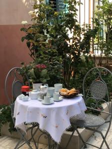 - une table avec des tasses, des soucoupes et du pain dans l'établissement Nel Giardino di Ester B&B, à Barile