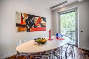 comedor con mesa blanca y sillas en Pgrhome Luxury Apartments Riverside, en Roma