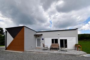 ein kleines weißes Gebäude mit zwei Stühlen auf einer Terrasse in der Unterkunft Kuća za odmor GRAŠEVINA in Kutjevo