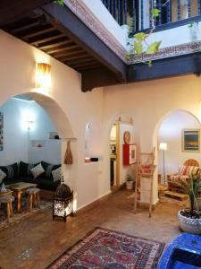 a living room with arches and a couch and a rug at Charmant riad pour familles ou groupes - Dar Mama in Essaouira