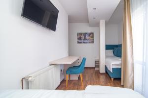 um quarto com uma cama, uma secretária e uma televisão em Hotel Konačište Akustik em Zlatibor