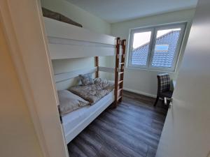 ein Schlafzimmer mit Etagenbetten und einem Fenster in der Unterkunft Apartment nahe Meyer Werft in Ostfriesland mit Küche & Netflix in Westoverledingen