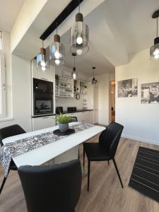 a dining room with a white table and chairs at Sky View - Luxury Apartament - Sanador Victoriei in Bucharest