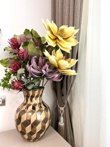a vase filled with flowers sitting on a table at Sky View - Luxury Apartament - Sanador Victoriei in Bucharest