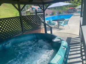 a hot tub in a backyard with a table and an umbrella at Country Town N' Suites in Gatlinburg