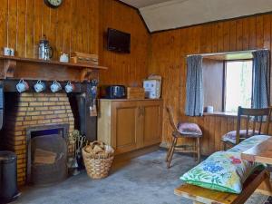 Habitación con chimenea, mesa y cama en Mains Of Auchmedden Cottage, en Pennan