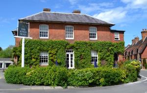 a red brick house with a sign in front of it at The King's Head in Winchester