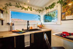 uma cozinha com um lavatório e uma janela em Angels Landing Tiny Home em Apple Valley