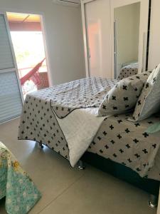 a bed with black and white sheets and pillows at Casa de Campo Pardinho Eco Ninho Verde 2 in Pardinho