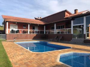 a house with a swimming pool in the yard at Casa de Campo Pardinho Eco Ninho Verde 2 in Pardinho