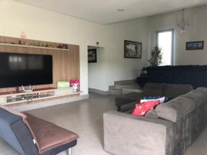 a living room with a couch and a flat screen tv at Casa de Campo Pardinho Eco Ninho Verde 2 in Pardinho