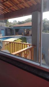 a balcony with a view of a patio and a pool at Chácara Águas São Pedro in Águas de São Pedro