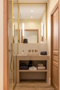 La salle de bains est pourvue d'un lavabo et d'un miroir. dans l'établissement Hotel La Mère Germaine, à Châteauneuf-du-Pape