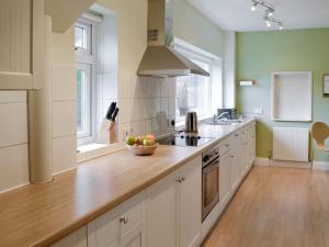 a kitchen with white cabinets and a bowl of fruit on the counter at Cobble Rigg in Threlkeld