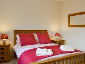 a bedroom with a red bed with towels on it at Cobble Rigg in Threlkeld