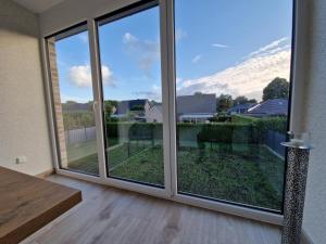 a sliding glass door with a view of a yard at Apartment nahe Meyer Werft in Ostfriesland mit Küche & Netflix in Westoverledingen