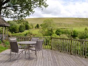 a table and chairs sitting on a wooden deck at Barn Cottage -uk11480 in Felindre