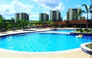 a swimming pool at a resort with buildings in the background at Prive Praias do Lago Eco Resort in Caldas Novas