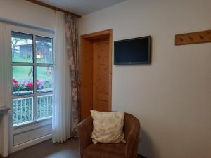 a living room with a chair and a window at Lauras Landhauspension in Medebach