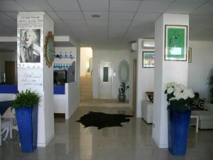 Un pasillo con dos jarrones azules con flores. en Hotel Villa Sorriso, en Senigallia