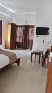 a bedroom with a bed and a flat screen tv at 3R Residency Munnar in Munnar