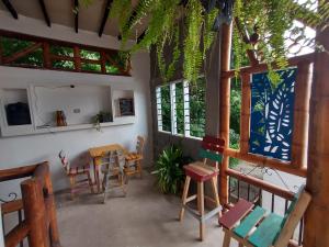 Habitación con sillas, mesa y ventanas. en Casa MITA Taganga en Taganga