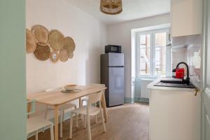 Il comprend une cuisine équipée d'une petite table et d'un réfrigérateur. dans l'établissement Travel Homes - Le Carls: agréable, mignon, moderne, à Mulhouse