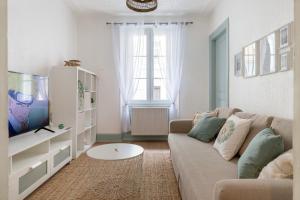 - un salon avec un canapé et une télévision dans l'établissement Travel Homes - Le Carls: agréable, mignon, moderne, à Mulhouse