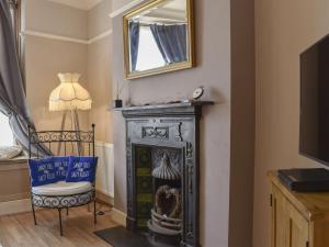 a living room with a fireplace and a mirror at Divers Cottage in Herne Bay