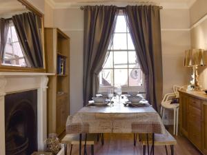 een eetkamer met een tafel en een raam bij Divers Cottage in Herne Bay