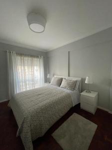 a white bedroom with a bed and a window at Parque Verde 1 - AL in Torres Vedras