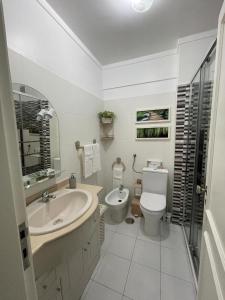 uma casa de banho branca com um lavatório e um WC em Parque Verde 1 - AL em Torres Vedras