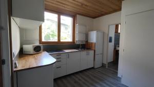 kuchnia z białymi szafkami i kuchenką mikrofalową na ladzie w obiekcie COTTAGE 1 in the city w mieście Chambéry